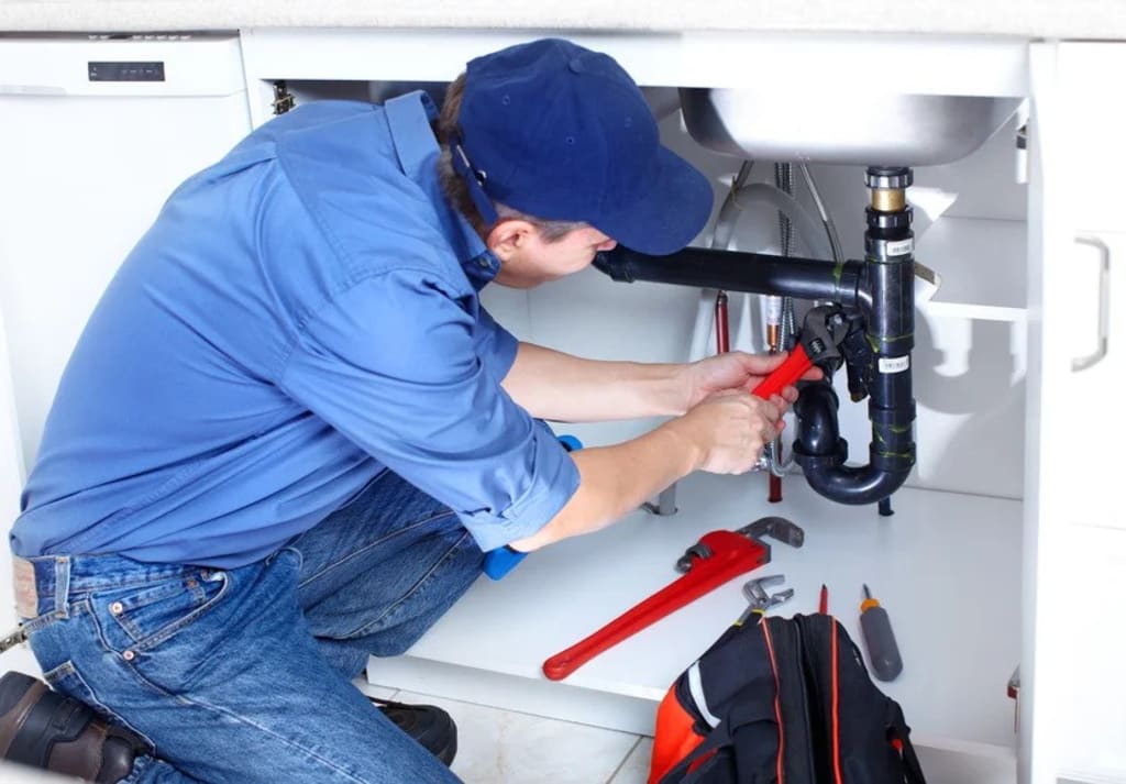 Plumber fixing pipes under a sink | Google ads agencies for home services